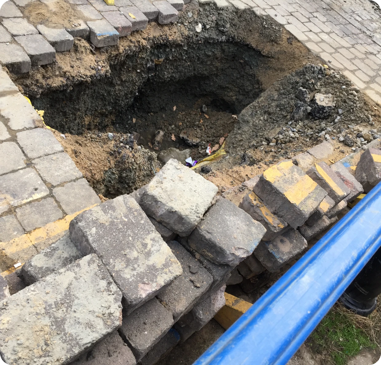 Pile of bricks beside a deep hole